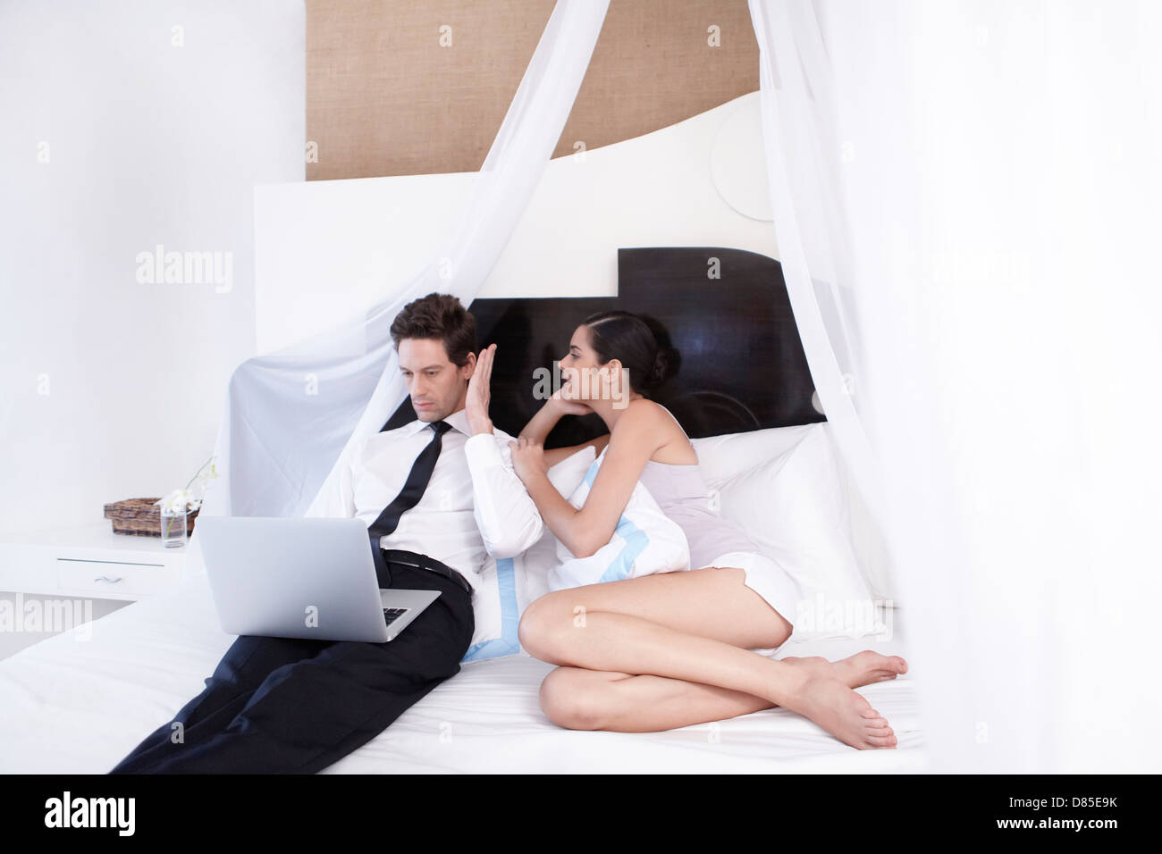 junges Paar sitzt auf Bett. Stockfoto