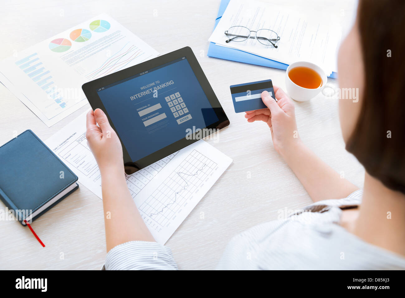 Erfolgreiche Geschäftsfrau, die Eingabe von Login-Daten zur Durchführung von online-Banking-Vorgang auf digitale Tablet im Büro Stockfoto