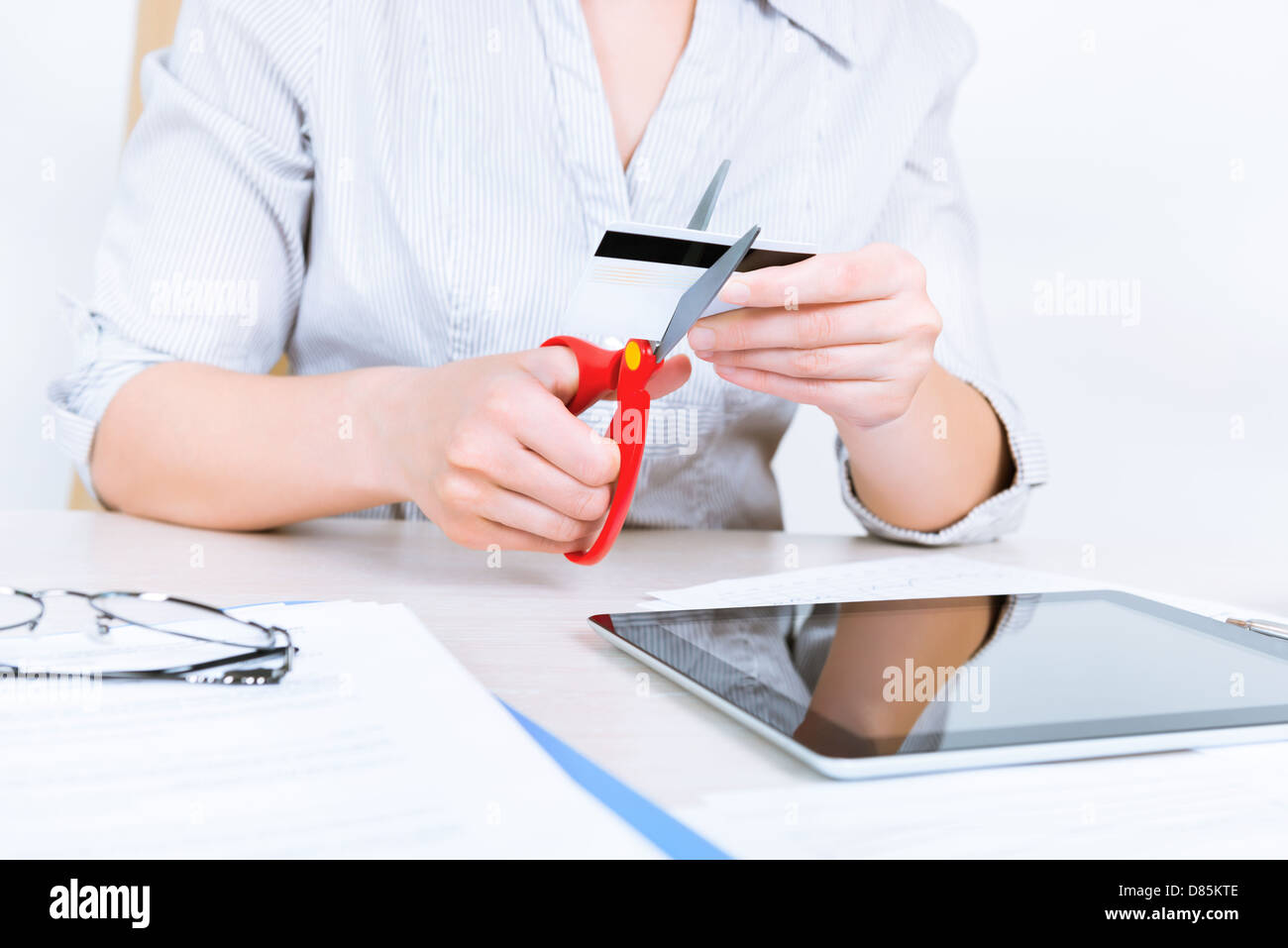 Geschäftsfrau loszuwerden ihrer Kreditkarte mit Hilfe der Schere nach Rückzahlung eines Darlehens Stockfoto