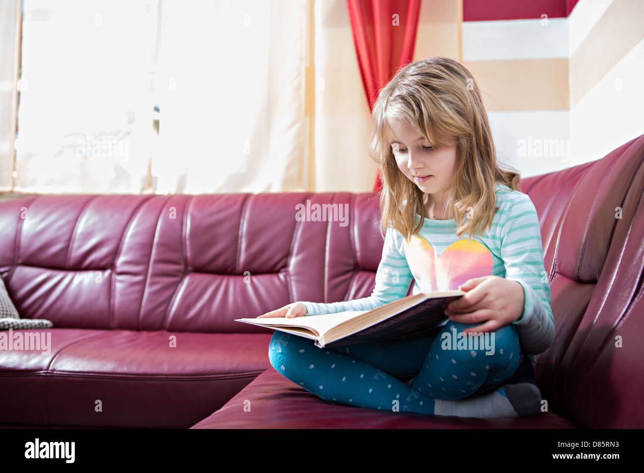 kleines Mädchen, ein Buch zu Hause Stockfoto