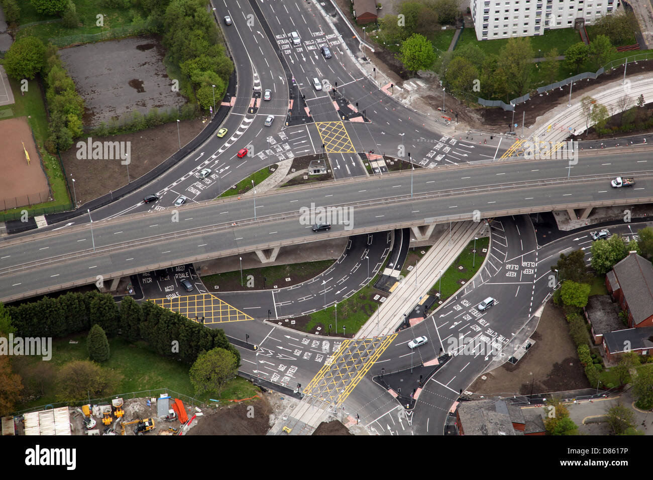 Aus der Vogelperspektive eines komplizierten großen Kreisverkehrs mit vielen Straßenmarkierungen und einer Straßenbahnlinie in Oldham, Greater Manchester Stockfoto