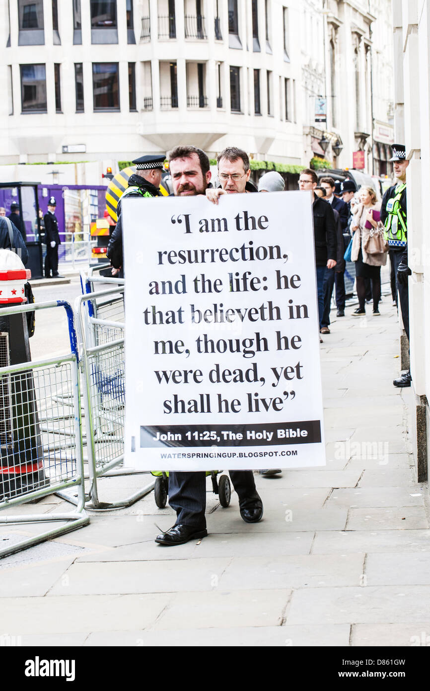 Ein Mann mit einem großen Schild, der John 11:25, London, England, Großbritannien zitiert. Stockfoto