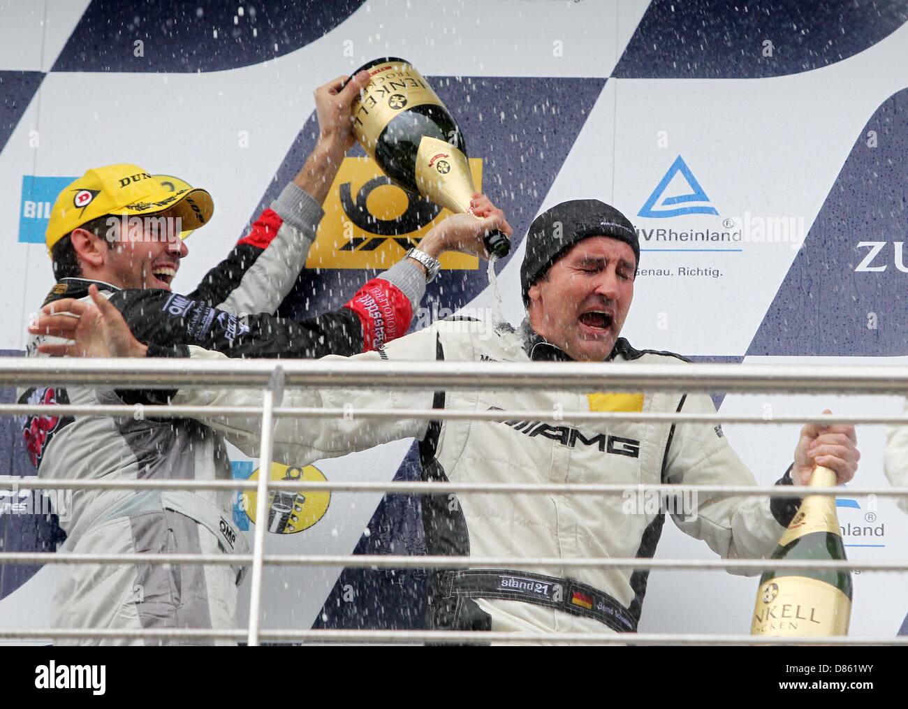 Nuerburg, Deutschland. 20. Mai 2013. Sean Edwards (L) gibt seinem Teamkollegen Bernd Schneider eine Sektdusche nach dem 24h Rennen am Nürburgring in der Nähe von Nuerburg, Deutschland, 20. Mai 2013. Team schwarz mit Sean Edwards, Bernd Schneider, Nicky Thiim und Jeroen Bleekemolen gewann das Rennen mit einem Mercedes SLS. Rund 180 Teams kämpften in der 24 h-Rennen. Foto: THOMAS FREY/Dpa/Alamy Live News Stockfoto