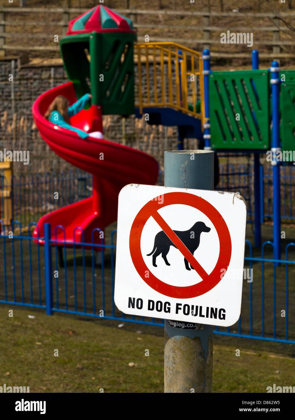 Kein Hund Fouling Schild mit Kinder auf Spielplatz im Hintergrund England UK Stockfoto