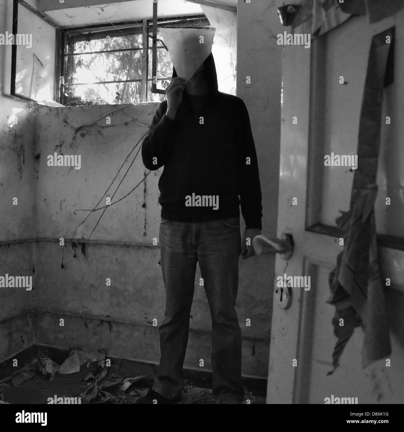 Vermummte Mann verdeckt durch Glasscherbe in verfallenen schmutzige Zimmer. Stockfoto