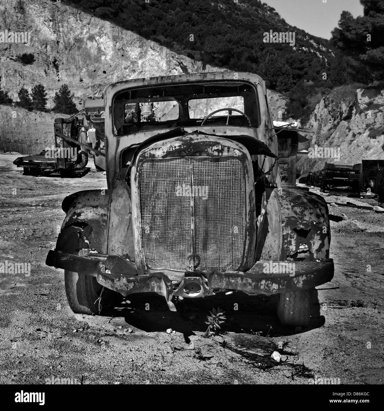 Rusty aufgegeben Auto und industrielle Maschinen an einem Steinbruch. Schwarz und weiß. Stockfoto