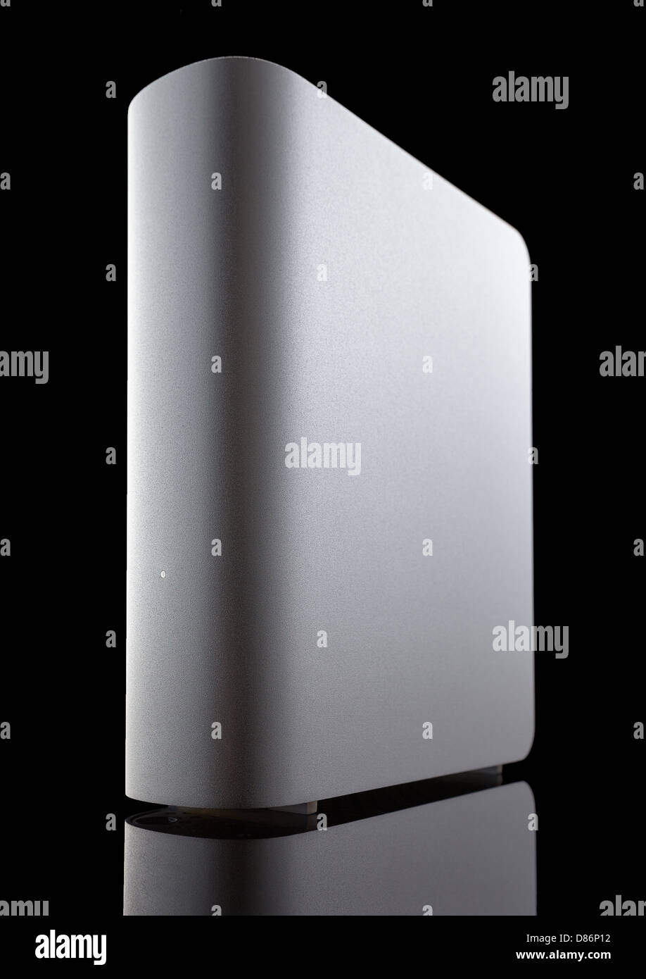 Eine graue externe Festplatte vor schwarzem Hintergrund auf niedrigen Winkel gedreht. Reflexion an der Unterseite. Stockfoto