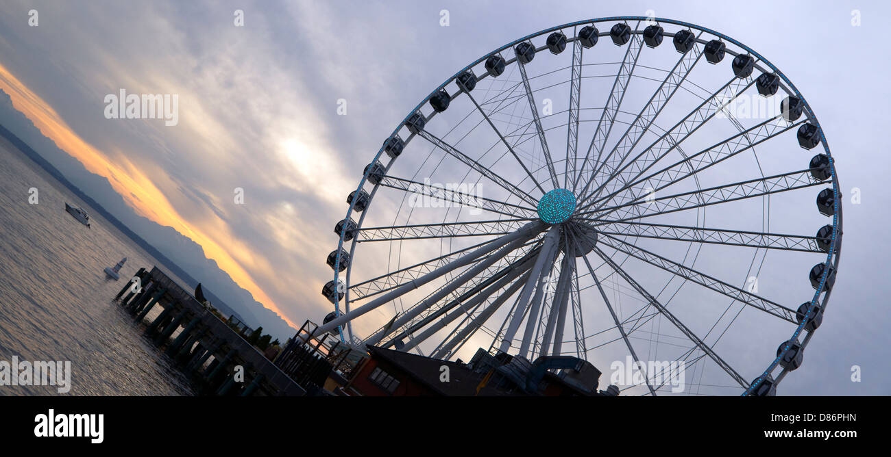 Sonnenuntergänge hinter der Olympic Mountains und Elliott Bay mit Riesenrad im Vordergrund Stockfoto