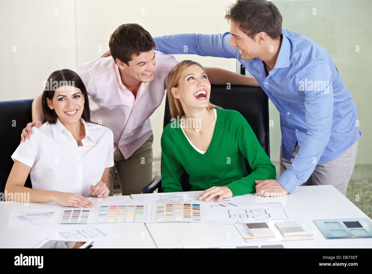 Zwei glückliche Paare entscheidende Haus Baustoffe auf dem Schreibtisch Stockfoto