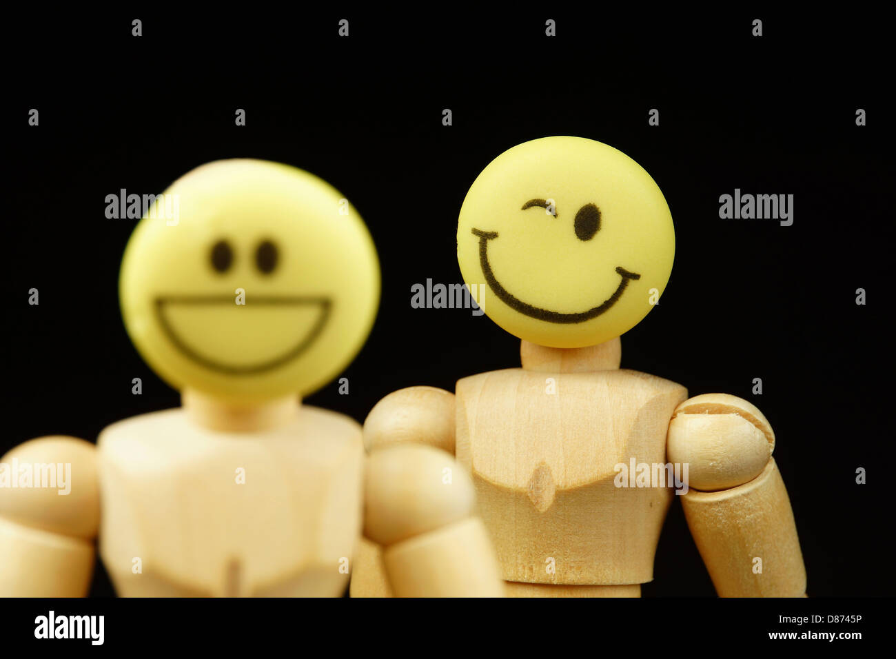 Holzfiguren von anthropomorphen Gesichter vor schwarzem Hintergrund, Nahaufnahme Stockfoto