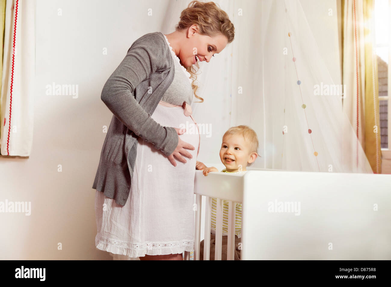 Deutschland, Bonn, schwangere Mutter mit Sohn stand neben seinem Bett Stockfoto