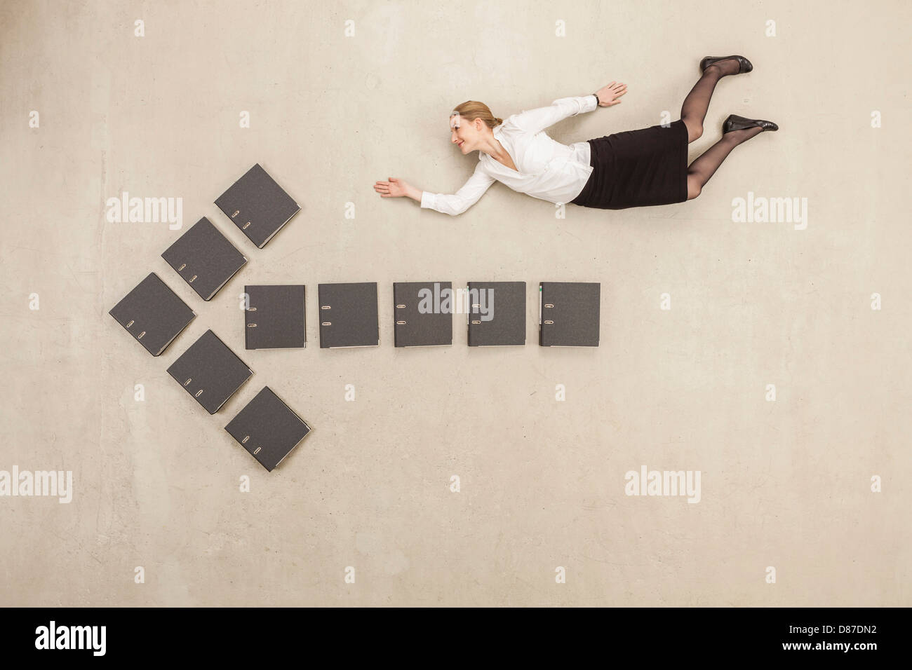 Geschäftsfrau, die über Dateien bilden Pfeilzeichen fliegen Stockfoto