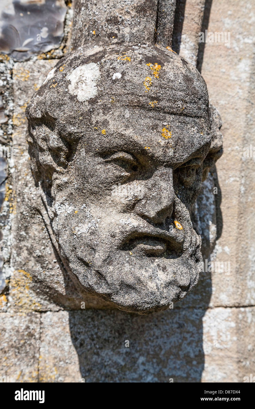 Zwei steinerne geschnitzten bärtigen Figur Köpfe am Eingang zur Kirche St. Peter, Haveringland, Norfolk, Großbritannien. Stockfoto