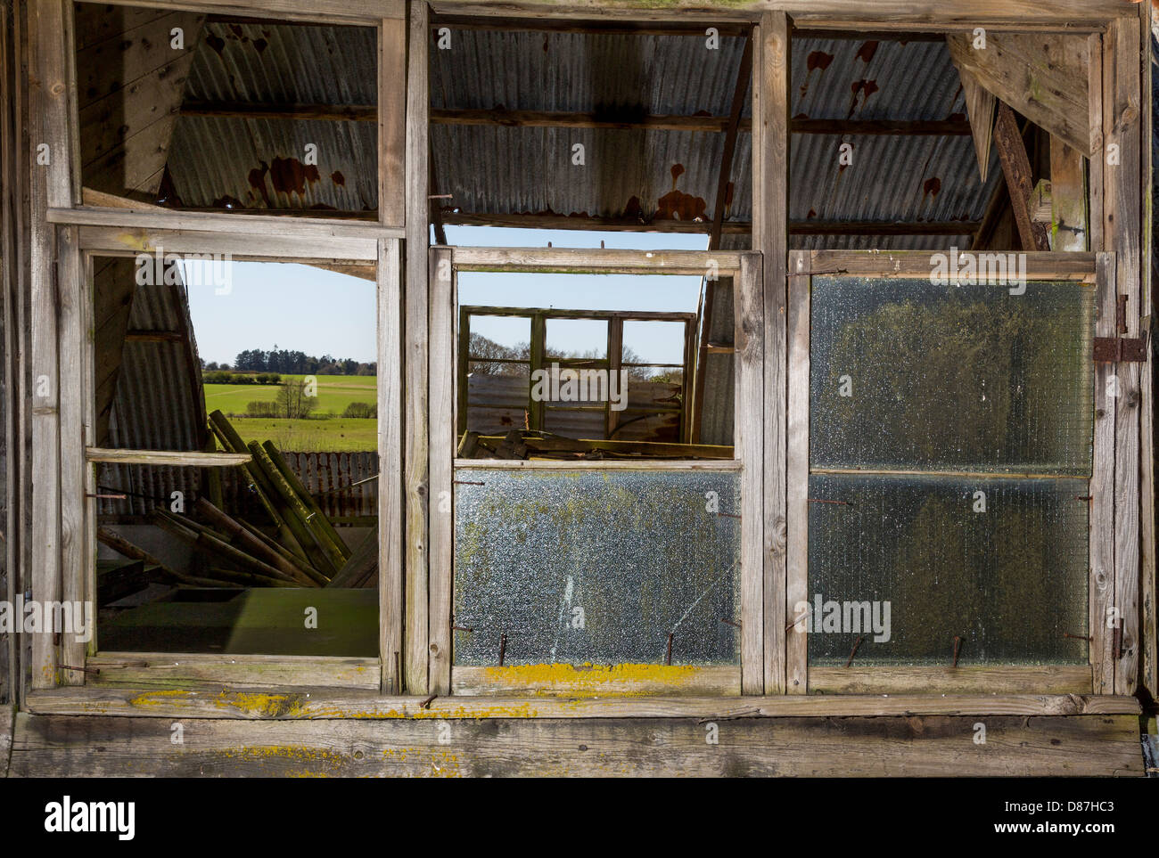 Zerbrochene Fensterscheiben auf einer alten Scheune. Stockfoto