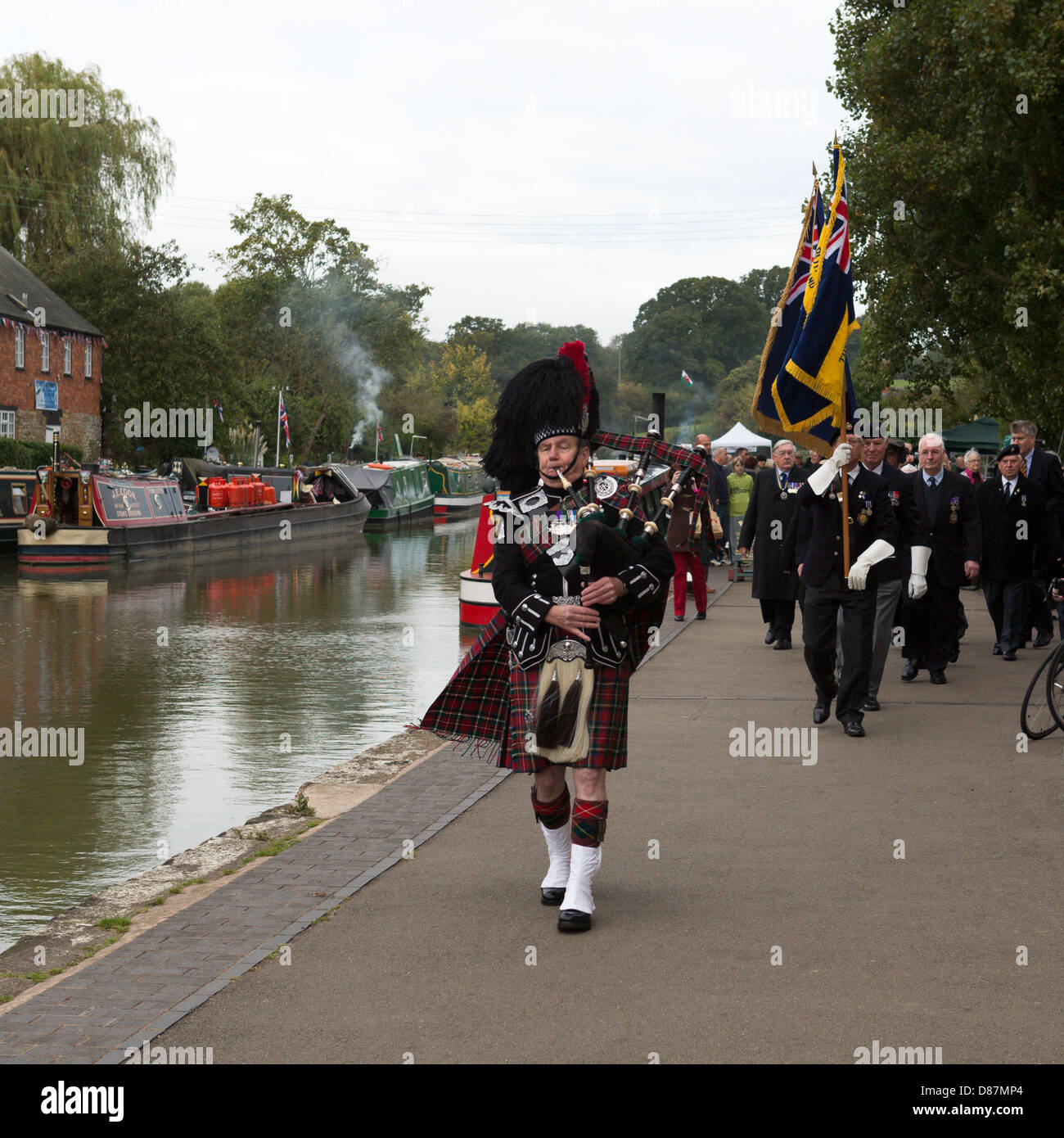 Pipe Major Mike Shanahan führt British Legion Standartenträger und Veteranen aus einem Kanal Seite Schlagfell Dienst 2012 Stockfoto