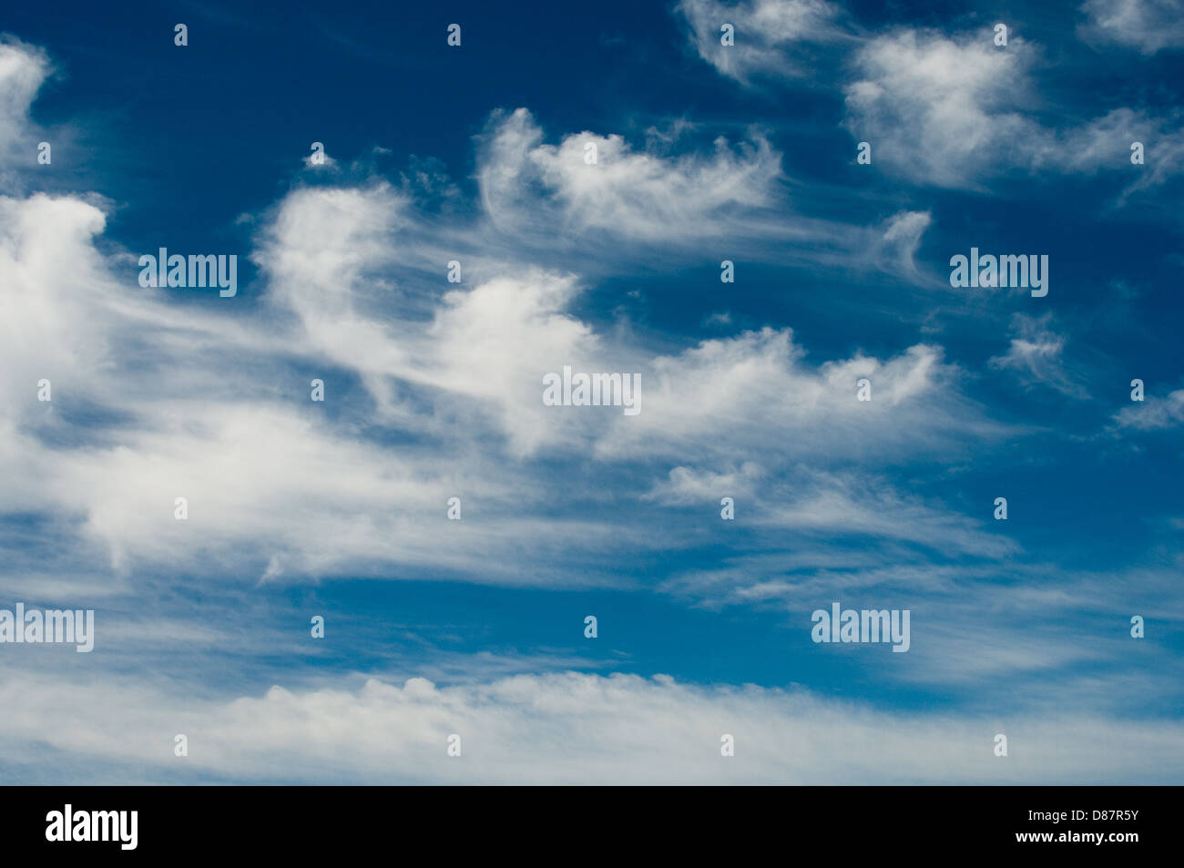 Weiße flauschige Wolken werden über einen blauen Himmel an der maltesischen Küste geblasen. Stockfoto
