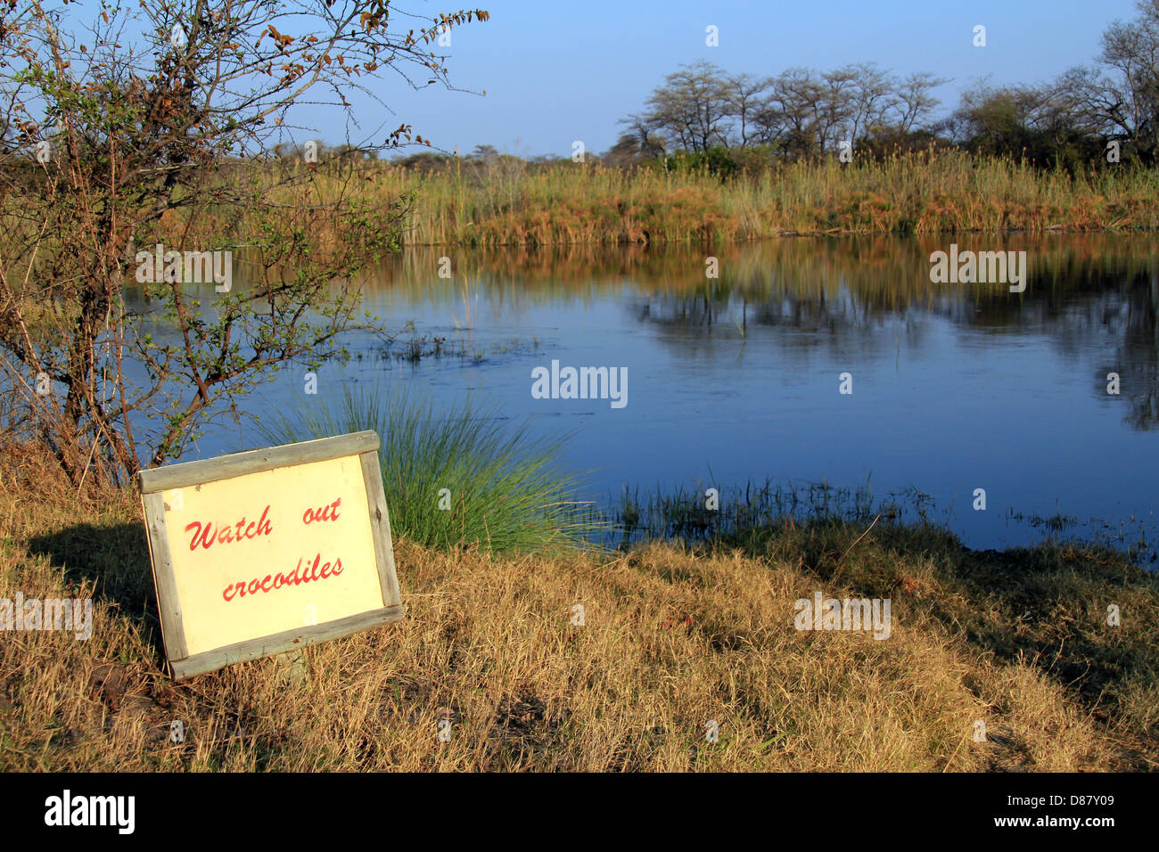 Krokodil-Warnschild am Kwando Fluss, Namibia Stockfoto