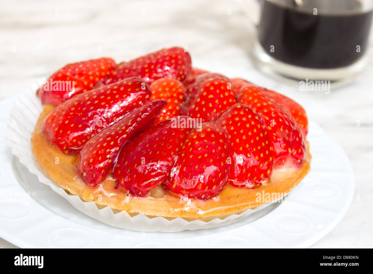 Kleine Erdbeer Torte auf weißen Teller mit Kaffee Stockfoto