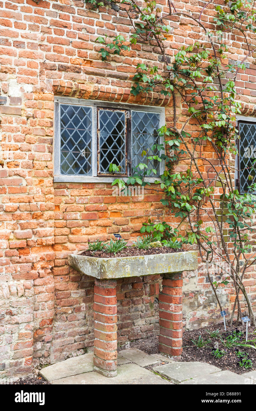 Sissinghurst Castle, Kent, England - bröckelnden gemauerte Wand, bedrahtet, helle Fenster und Pflanzentrog Stockfoto