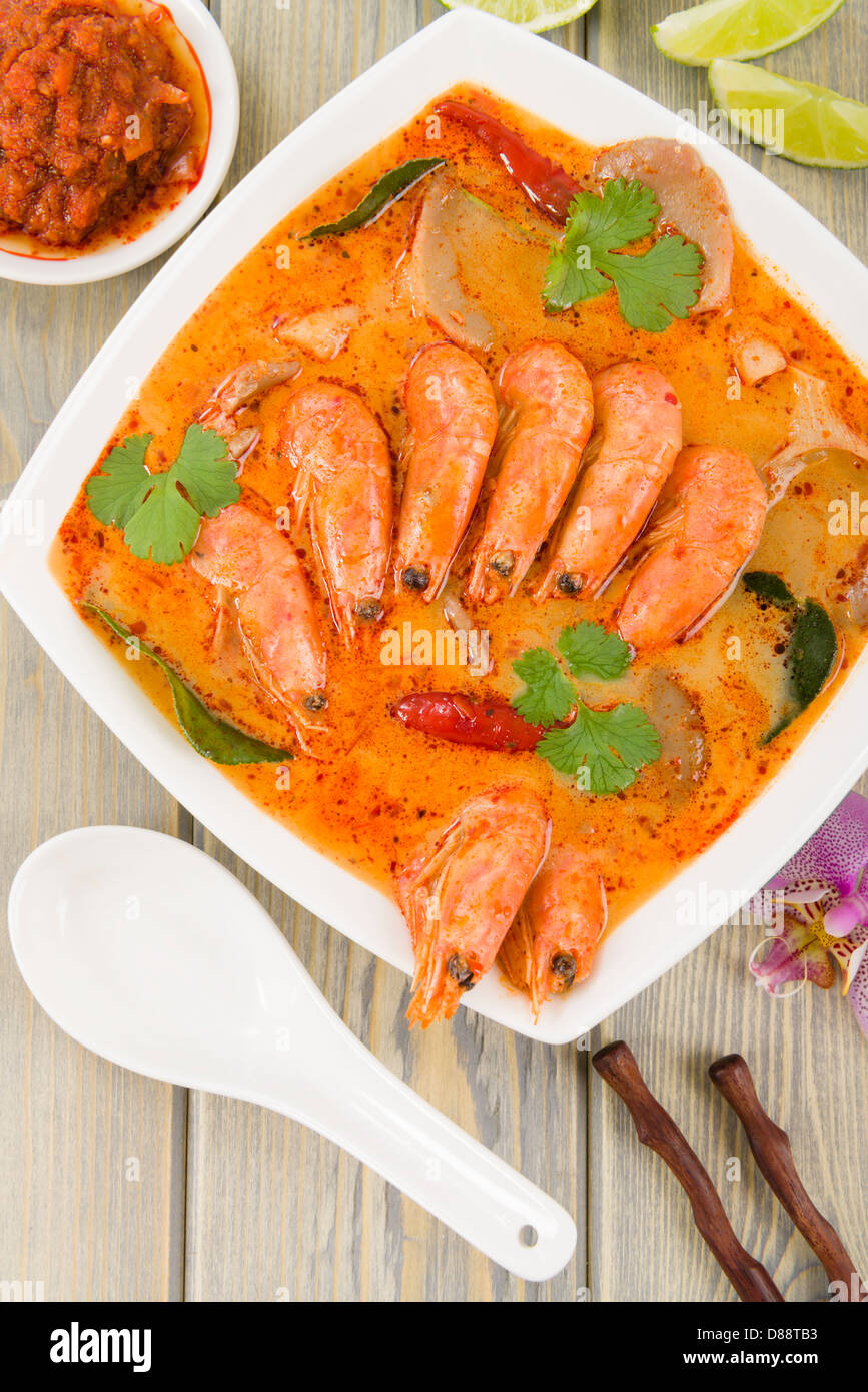 Tom Yum Nam Khon - cremigen Thai-Suppe mit Garnelen und Champignons garniert mit Koriander und mit Limettenscheiben serviert. Stockfoto