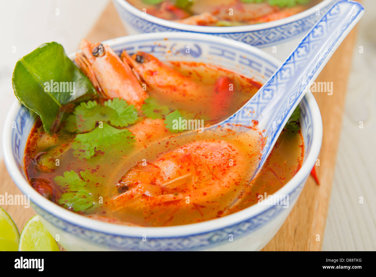 Tom Yum Goong - Thai klar scharf-saure Suppe mit König Garnelen und Austernpilzen mit Limettenscheiben serviert. Stockfoto