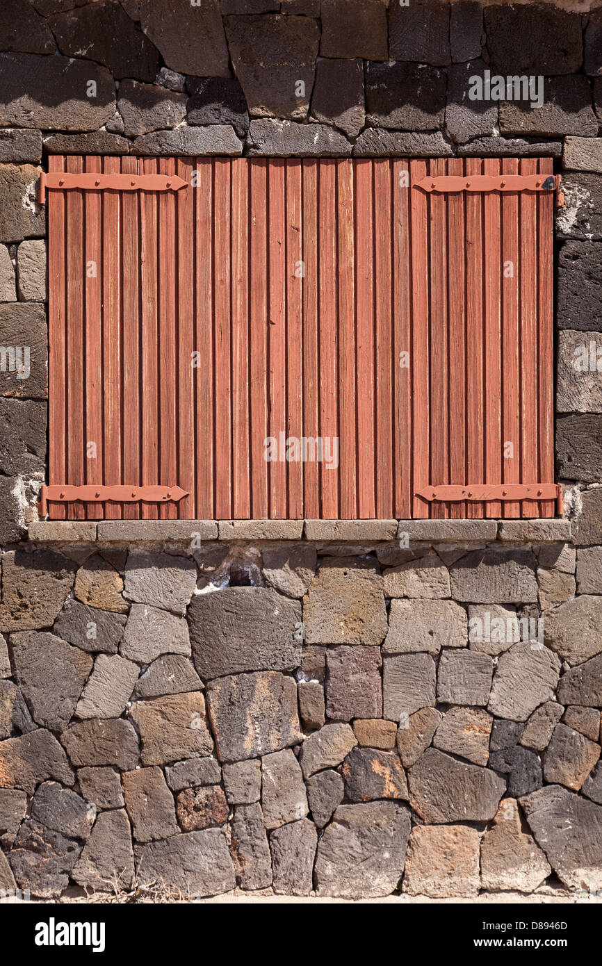 Holzfenster-Verschluss verschlossen mit Natursteinmauer Stockfoto