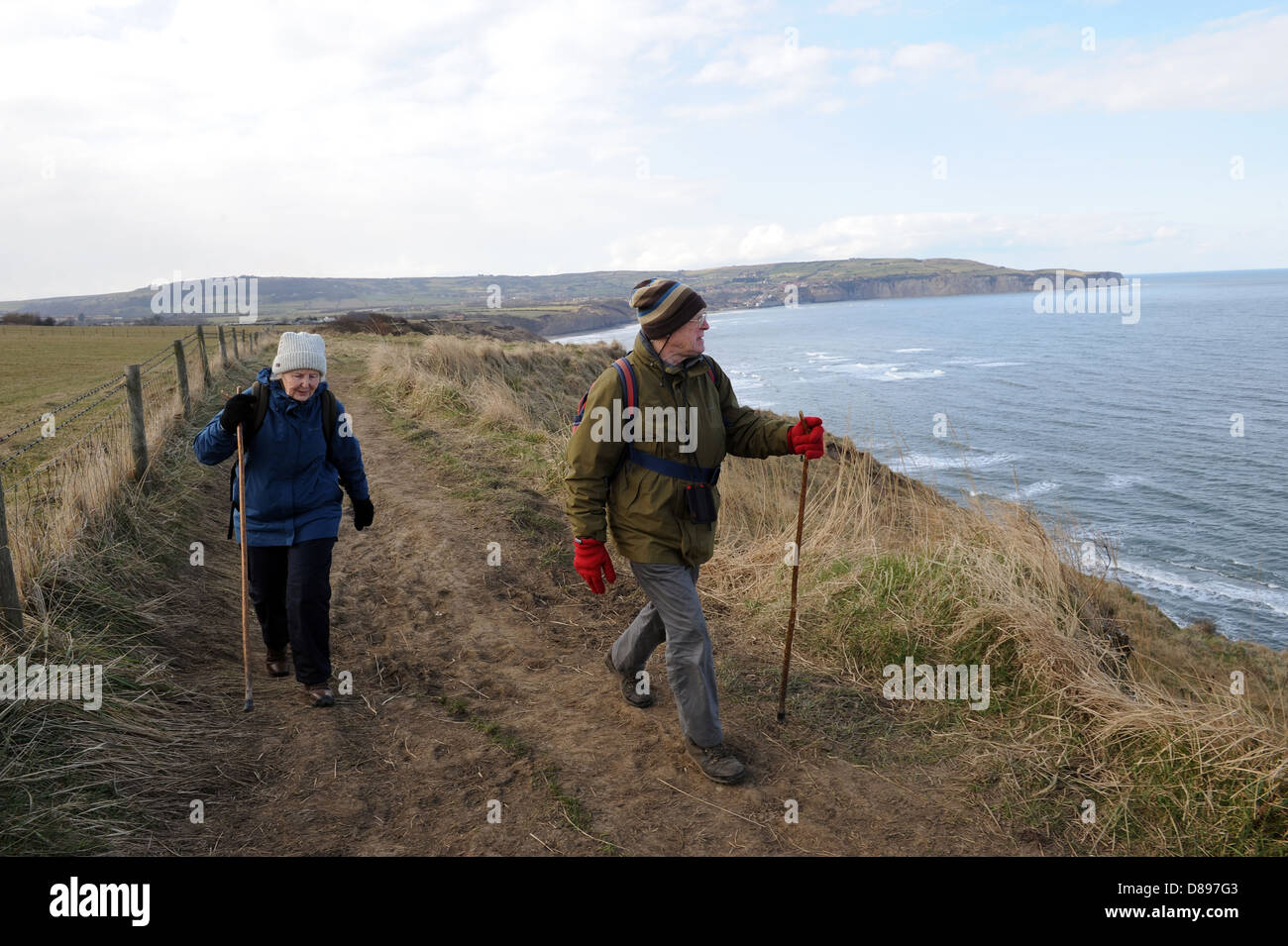 Mann und Frau zu Fuß entlang des Cleveland-Weg in der Nähe von Ravenscar, North York Moors, England uk Stockfoto