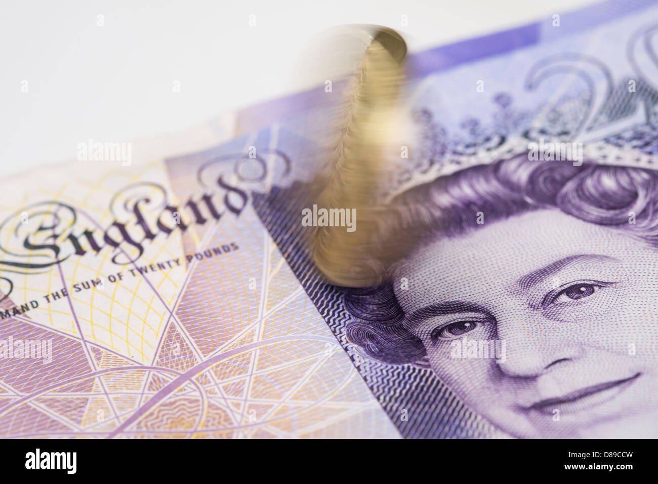 Ein Pfund-Münze drehend auf einen 20-Pfund-Note. Stockfoto