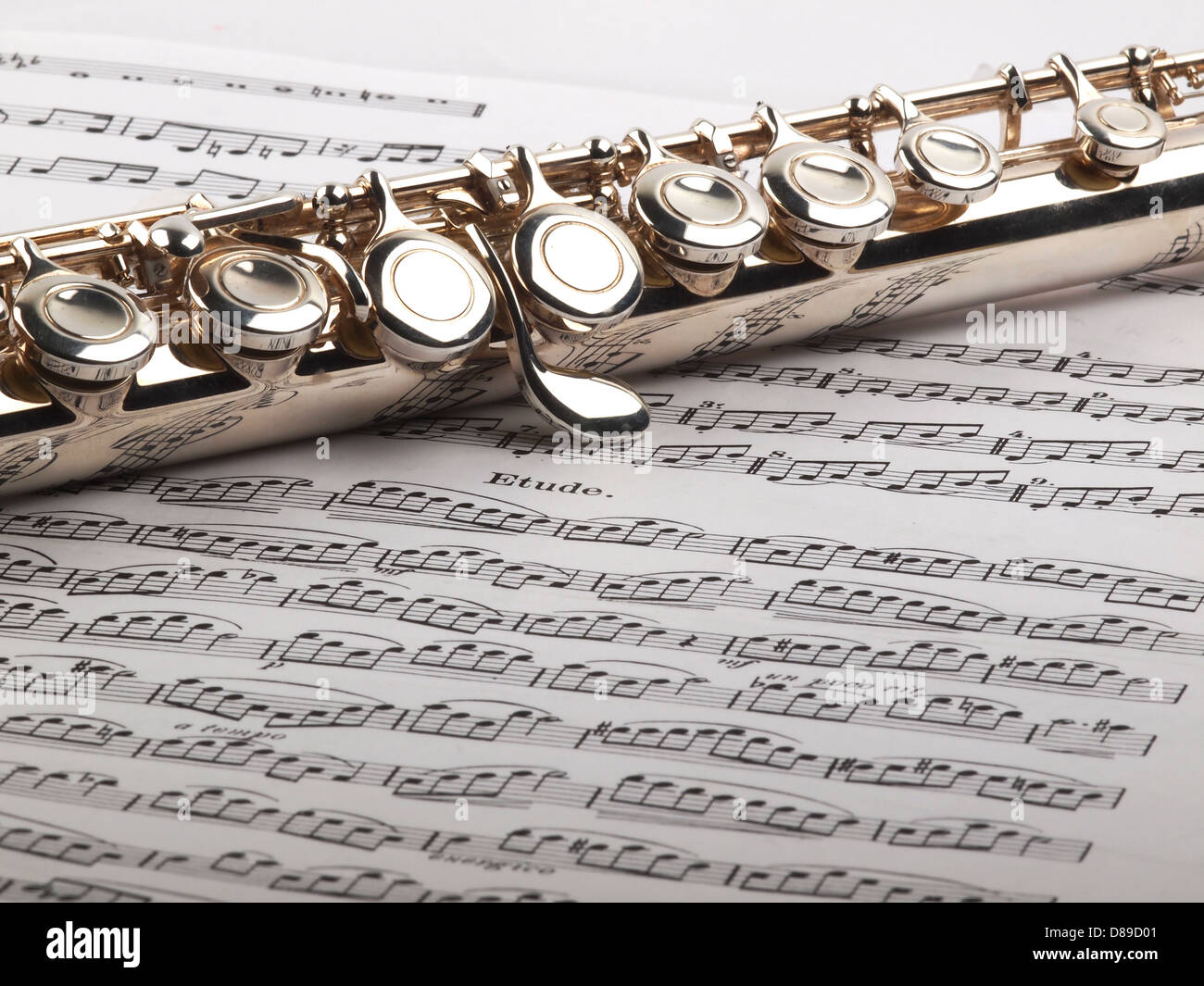 Eine gebrauchte Querflöte ruht auf einer offenen Etüde Partitur Stockfoto