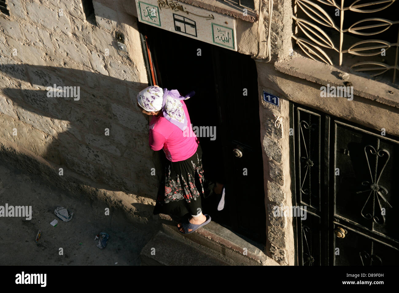 Mädchen aus der Tür in Mardin, Südosten der Türkei hängt Stockfoto