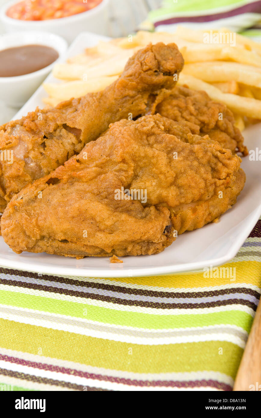 Fried Chicken & Chips - Hähnchenteile auf den Knochen in würziger Mehl überzogen und frittiert. Pommes frites, Bohnen und Soße Seiten. Stockfoto