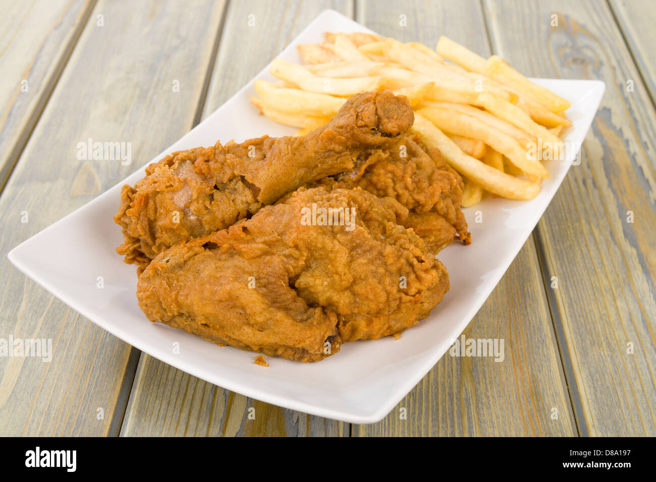 Fried Chicken & Chips - Hähnchenteile auf den Knochen in würziger Mehl überzogen und frittiert mit Pommes frites serviert. Stockfoto