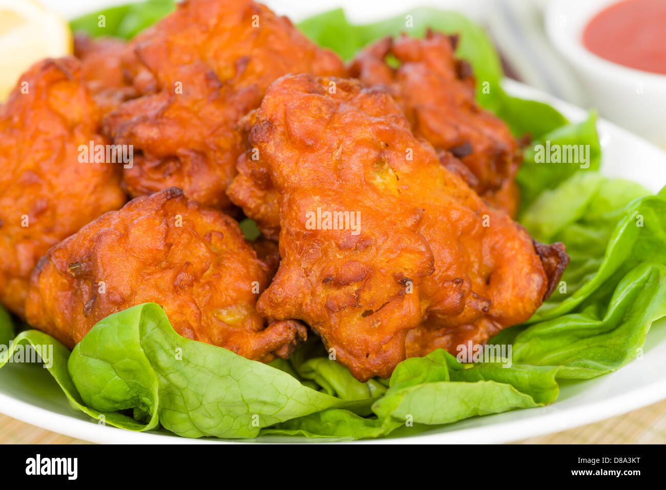 Zwiebel-Bhajis - Krapfen mit DIP-Sauce, Salat und Zitronenspalten südasiatischen. Stockfoto