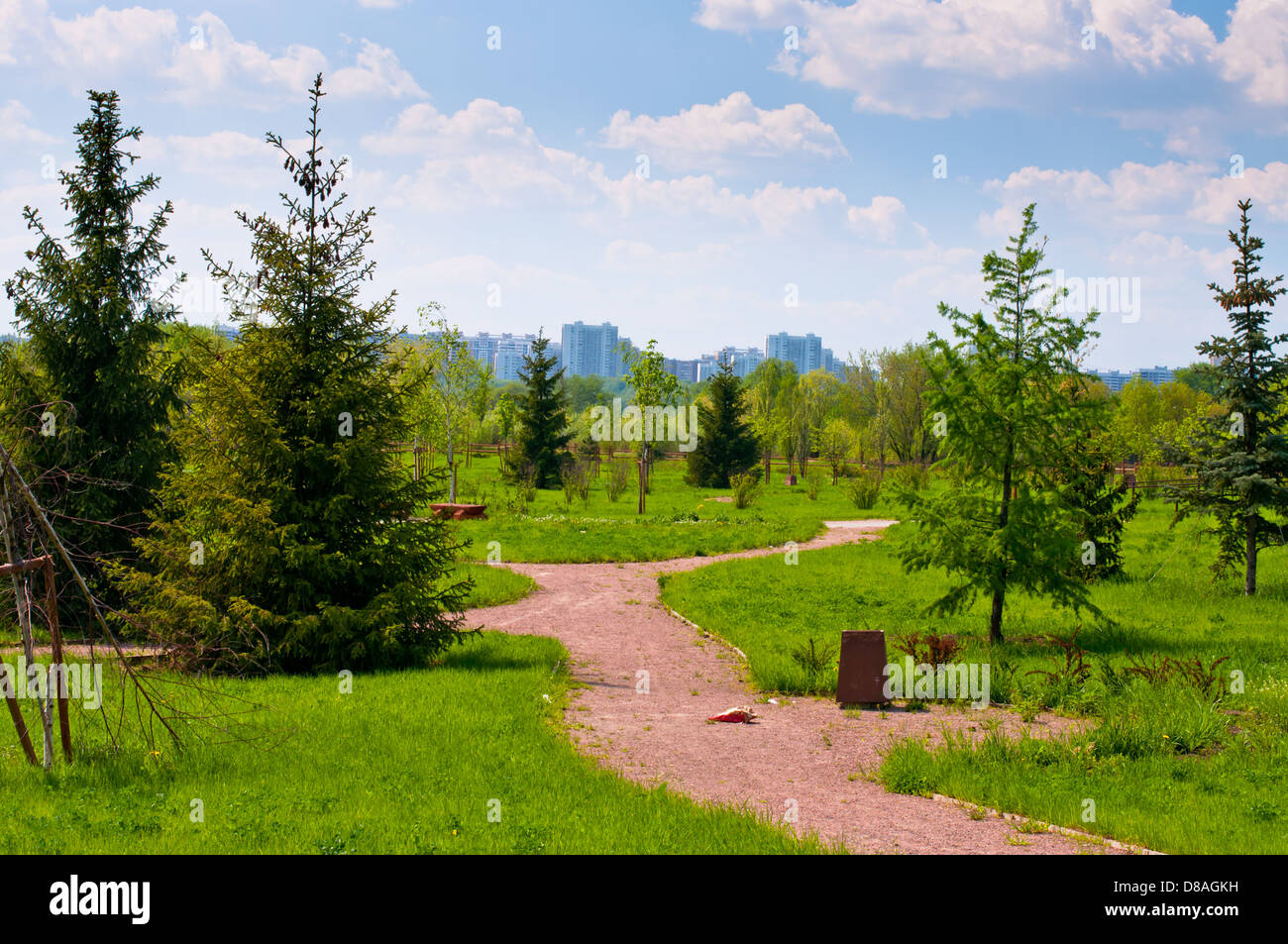 Gehweg verlegen über eine Wiese mit Bäumen und Gebäuden auf einem Hintergrund Stockfoto