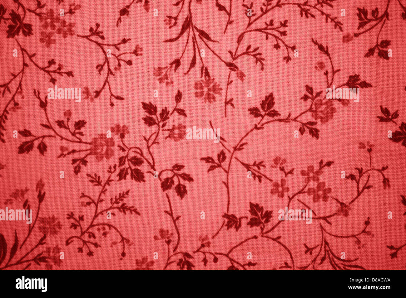 Nahaufnahme aus Stoff mit rotem Blumenmuster. Das komplizierte Design zeigt Blumen in verschiedenen Rottönen mit feinen Details auf den Blättern und Blättern. Diese Stoffstruktur verleiht jedem Material oder Design ein visuelles Interesse und lebendige Farben. Stockfoto