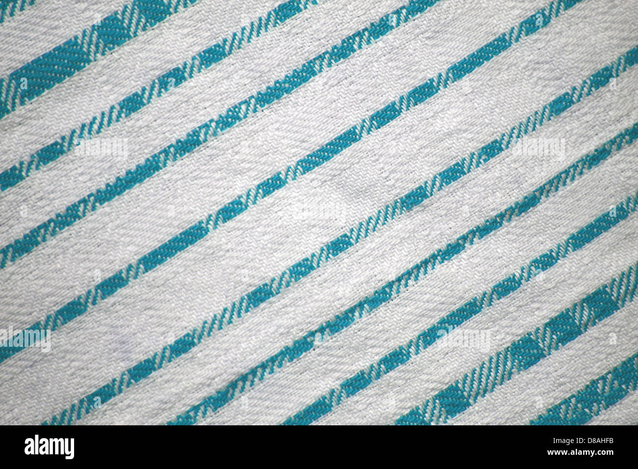 Dieses Bild zeigt eine Nahaufnahme aus Stoff mit blaugrünen und weißen Diagonalstreifen. Die kontrastierenden Farben und das diagonale Muster erzeugen einen dynamischen visuellen Effekt, der häufig in Mode und Innenarchitektur verwendet wird. Die Textur des Gewebes sorgt für Tiefe und Interesse und eignet sich daher für eine Vielzahl von Designanwendungen. Stockfoto