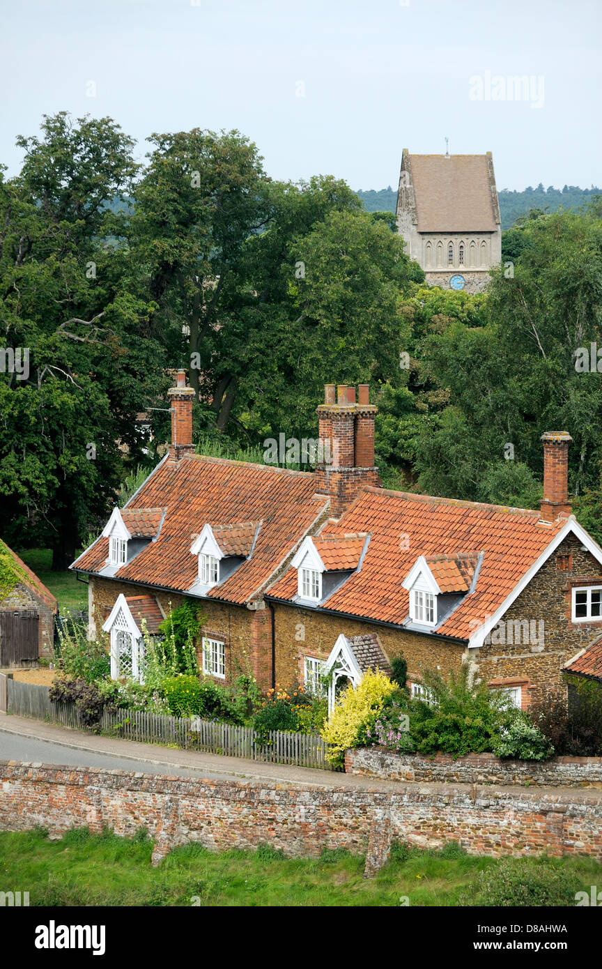 Aus rotem Backstein Hütten mit Gauben und Gärten und St. Laurentius-Kirche im Dorf von Castle Rising, Norfolk, England Stockfoto