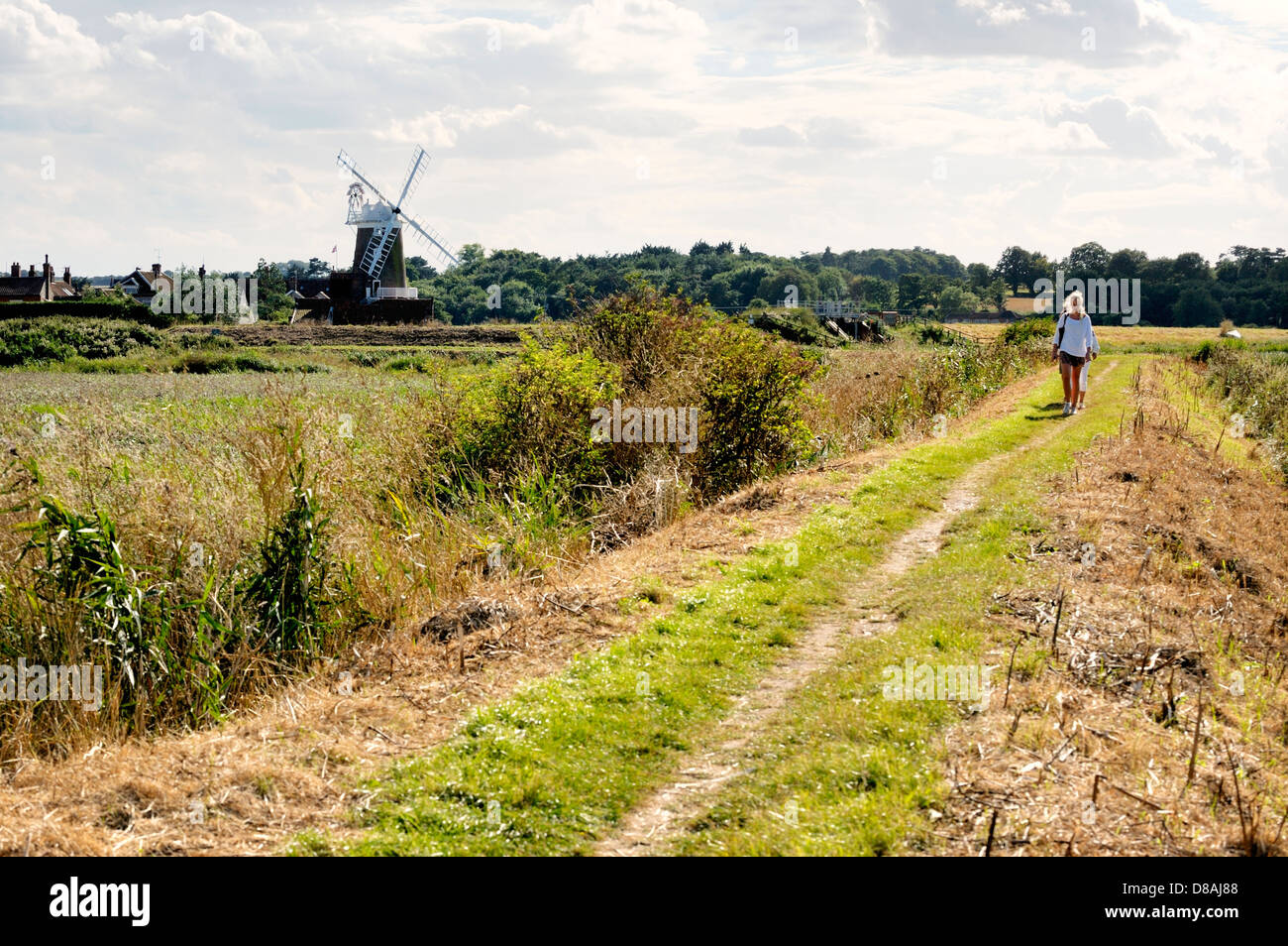 Wanderer auf Norfolk Coast Path aka Peddars Weise passieren North Norfolk Heritage Coast Dorf Cley als nächstes die Meer und Cley Windmühle Stockfoto