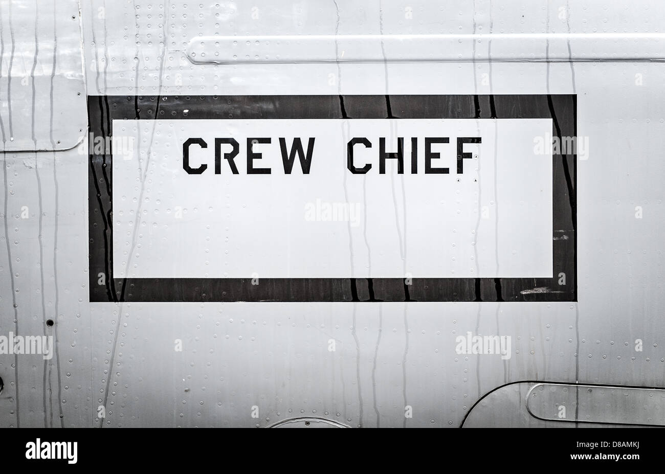 Großer Text Crewchief in schwarzen Rahmen auf Seite des Flugzeugs geschrieben. Militärflugzeuge Nahaufnahme. Teil der Armee-Luft-Transport. Stockfoto