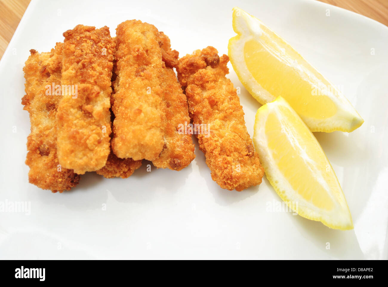 Fischstäbchen mit Zitronenspalten Stockfoto