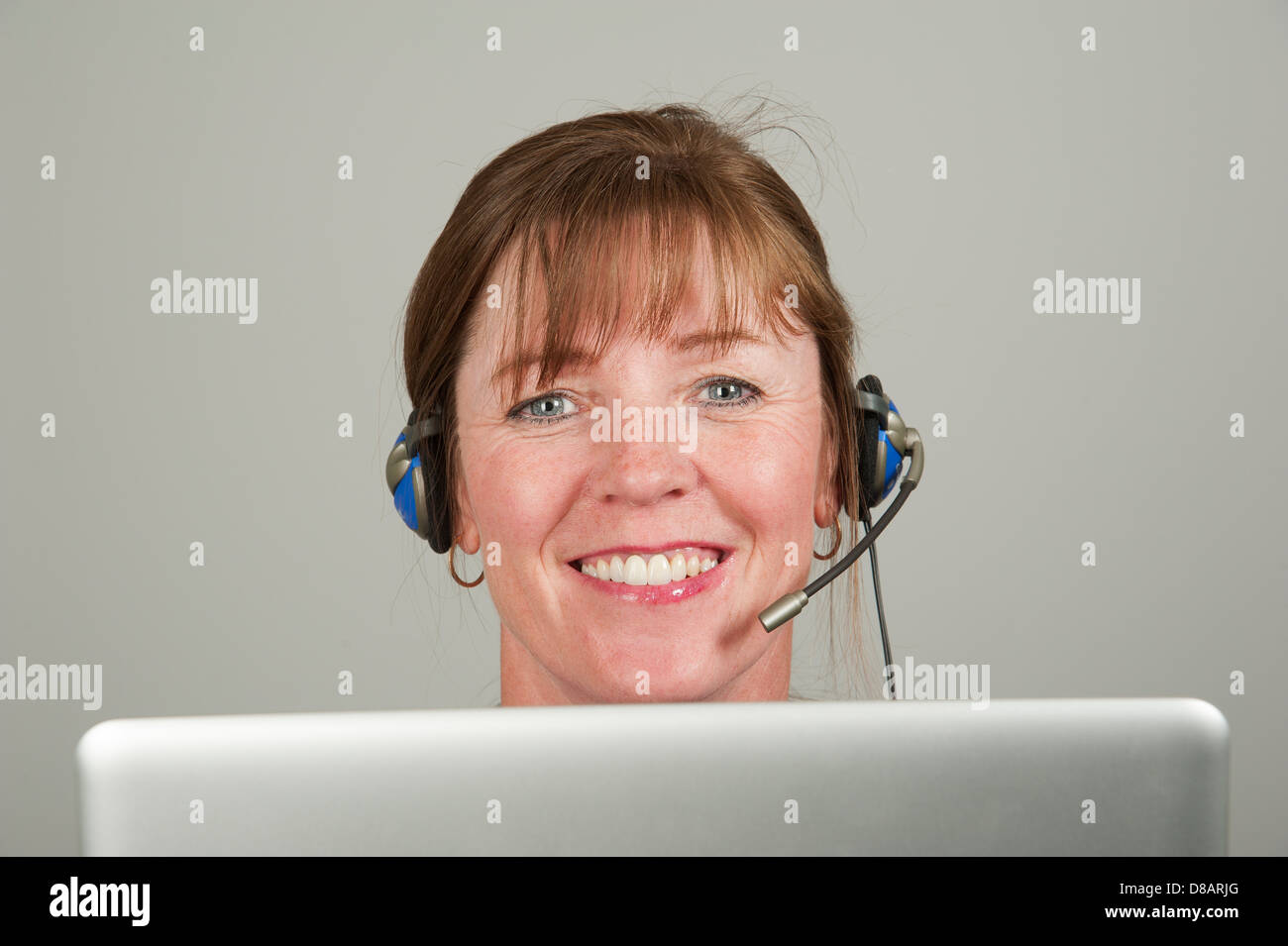 Frau mit einem Kopfhörer und einem computer Stockfoto