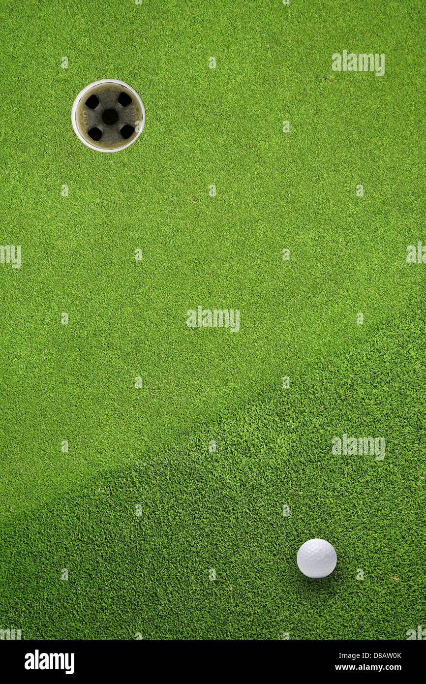 Golf Ball Loch auf einem Feld Stockfoto