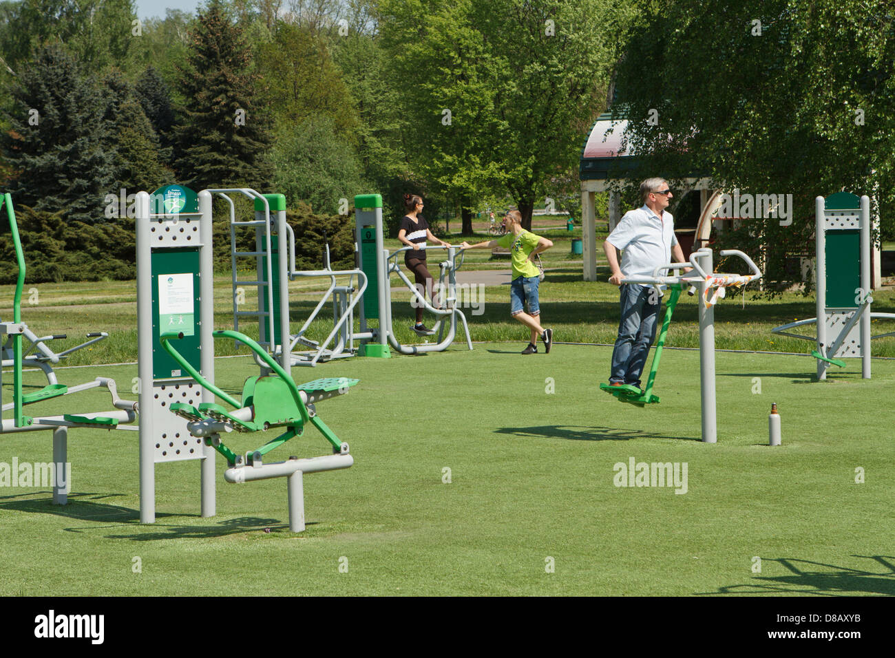 Menschen mit Outdoor-Fitnessgeräte in einem öffentlichen ...