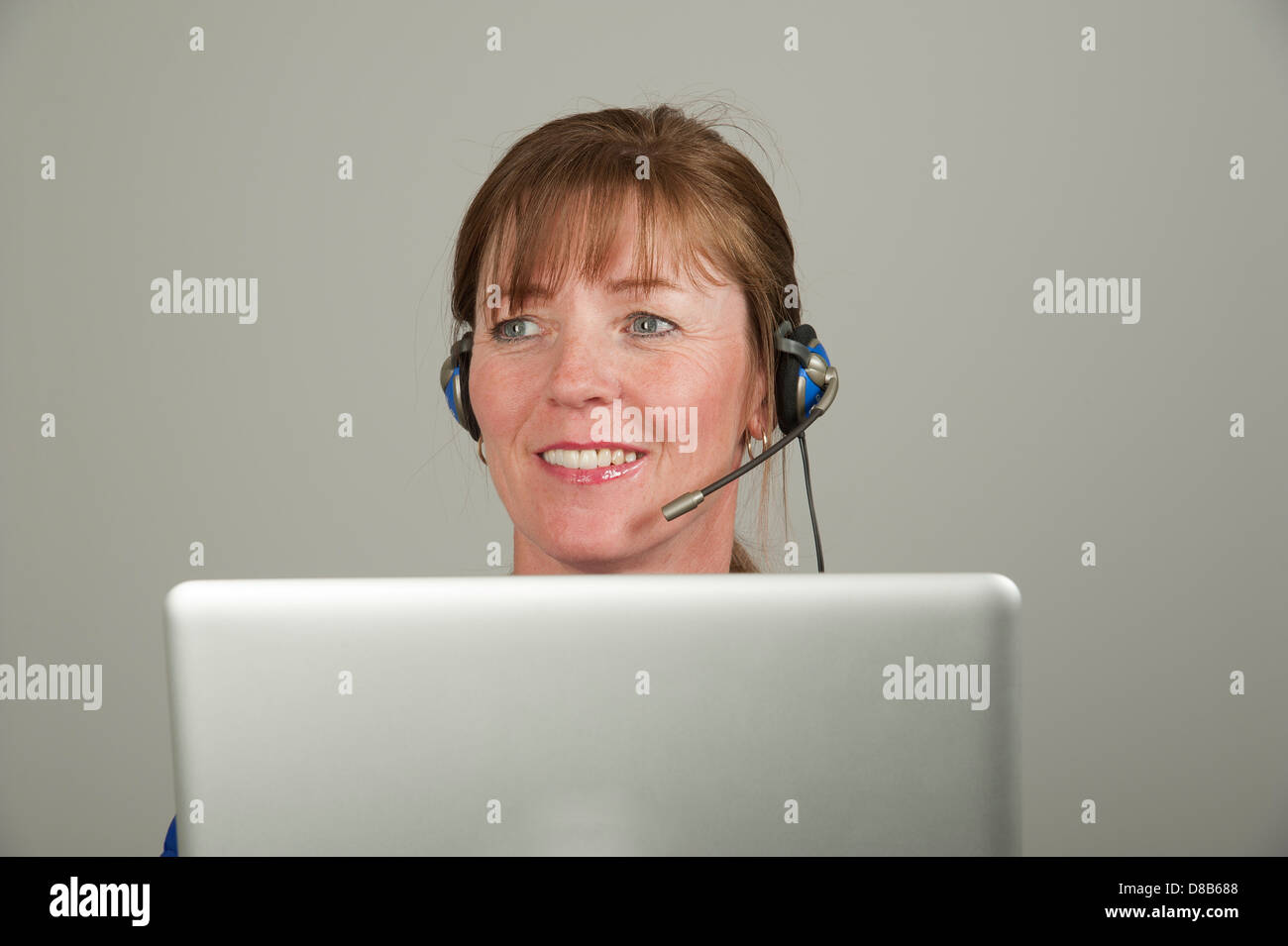 Frau mit einem Kopfhörer und einem computer Stockfoto