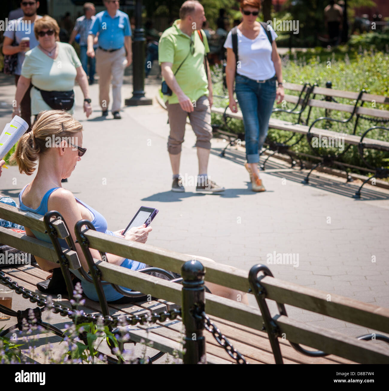 Ein Leser sonnt sich in der Sonne lesen ihr elektronisches Buch im Washington Square Park in Greenwich Village in New York Stockfoto