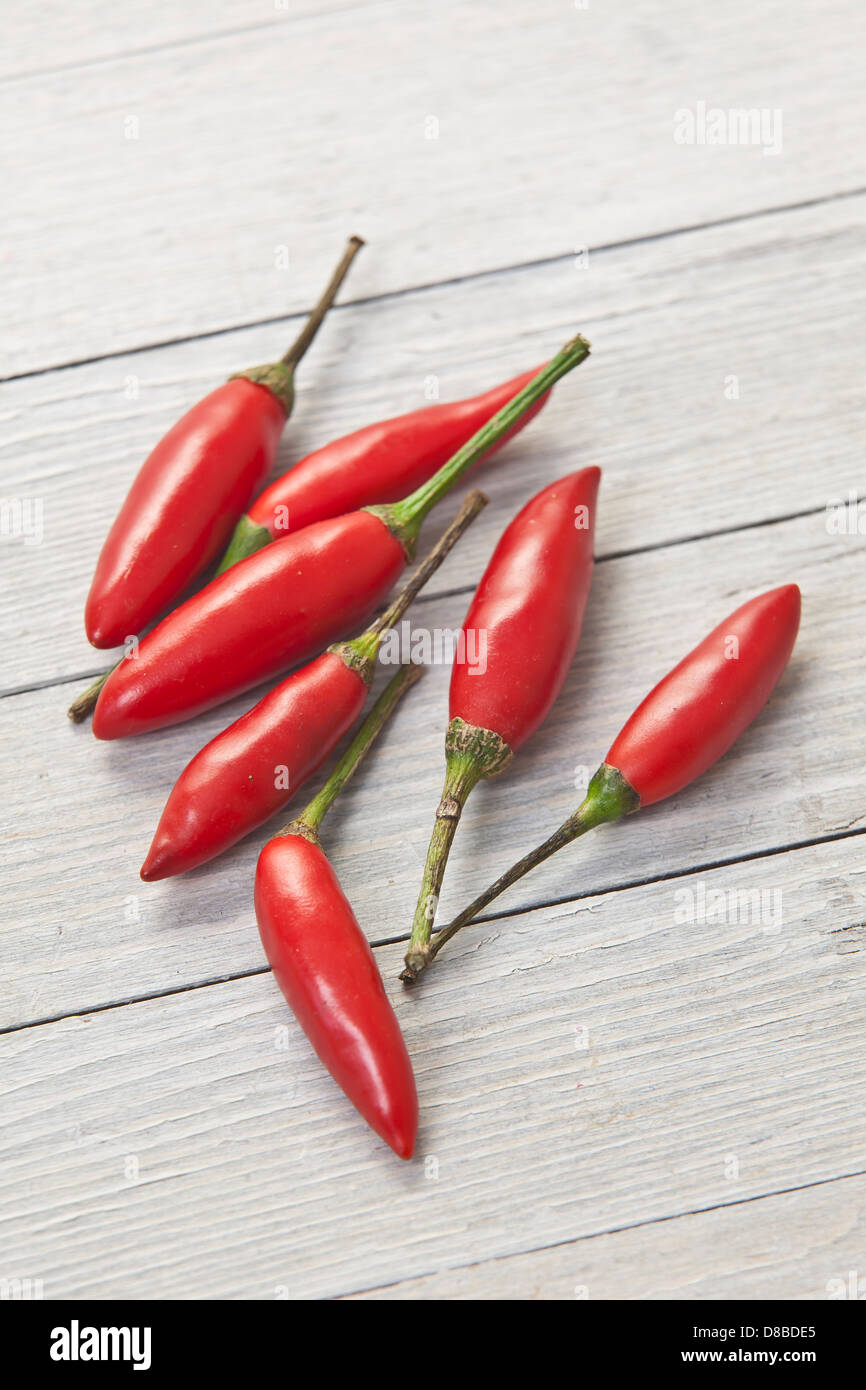 Sieben rote Thai-Chilischoten auf rustikale Oberfläche des Holzes. Stockfoto