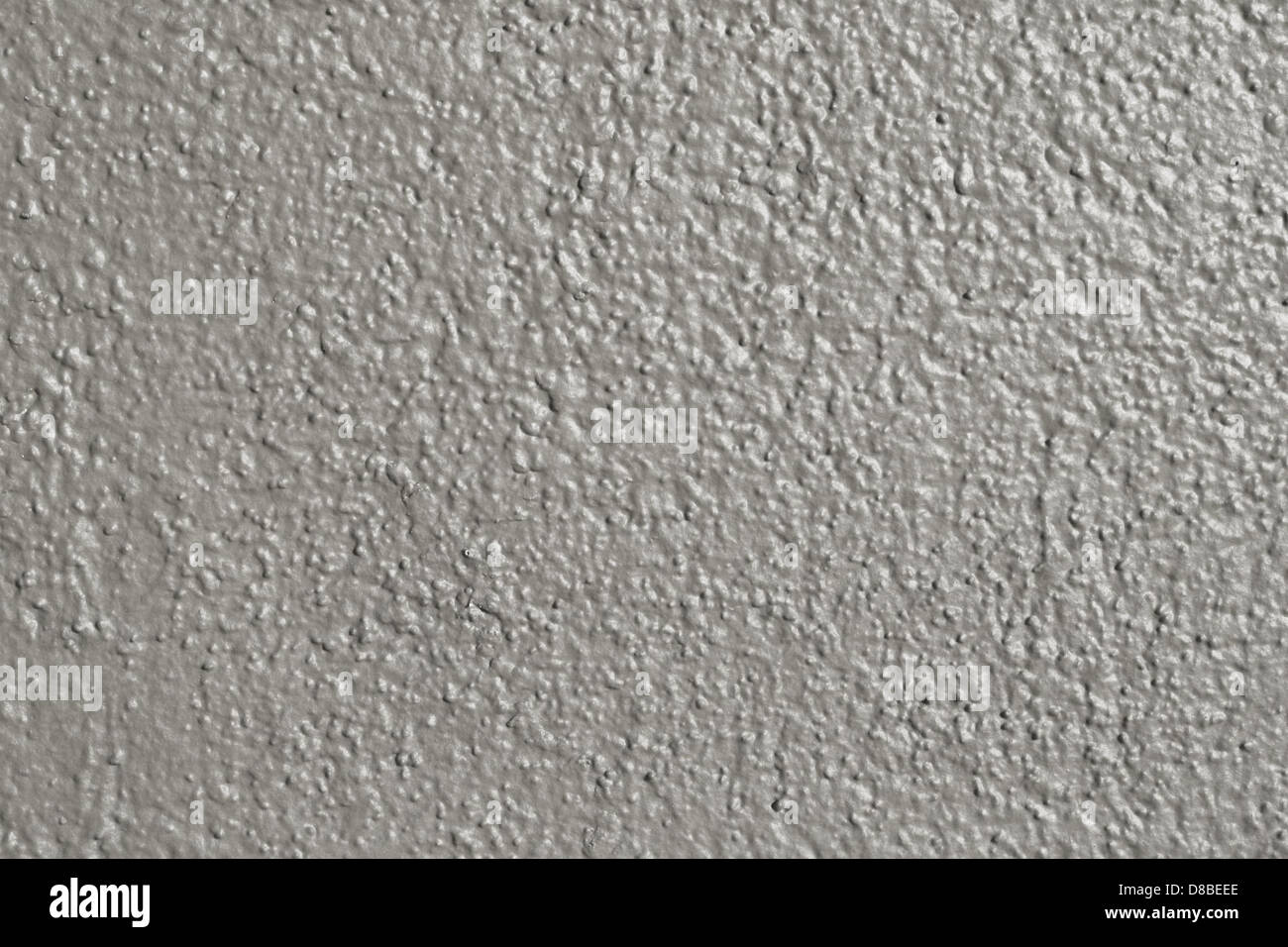 Eine Nahaufnahme einer grau lackierten Wandoberfläche mit glatter Textur und subtilen Farbvariationen. Der neutrale Ton der Wand bietet eine vielseitige Kulisse für Design- oder Fotozwecke. Stockfoto