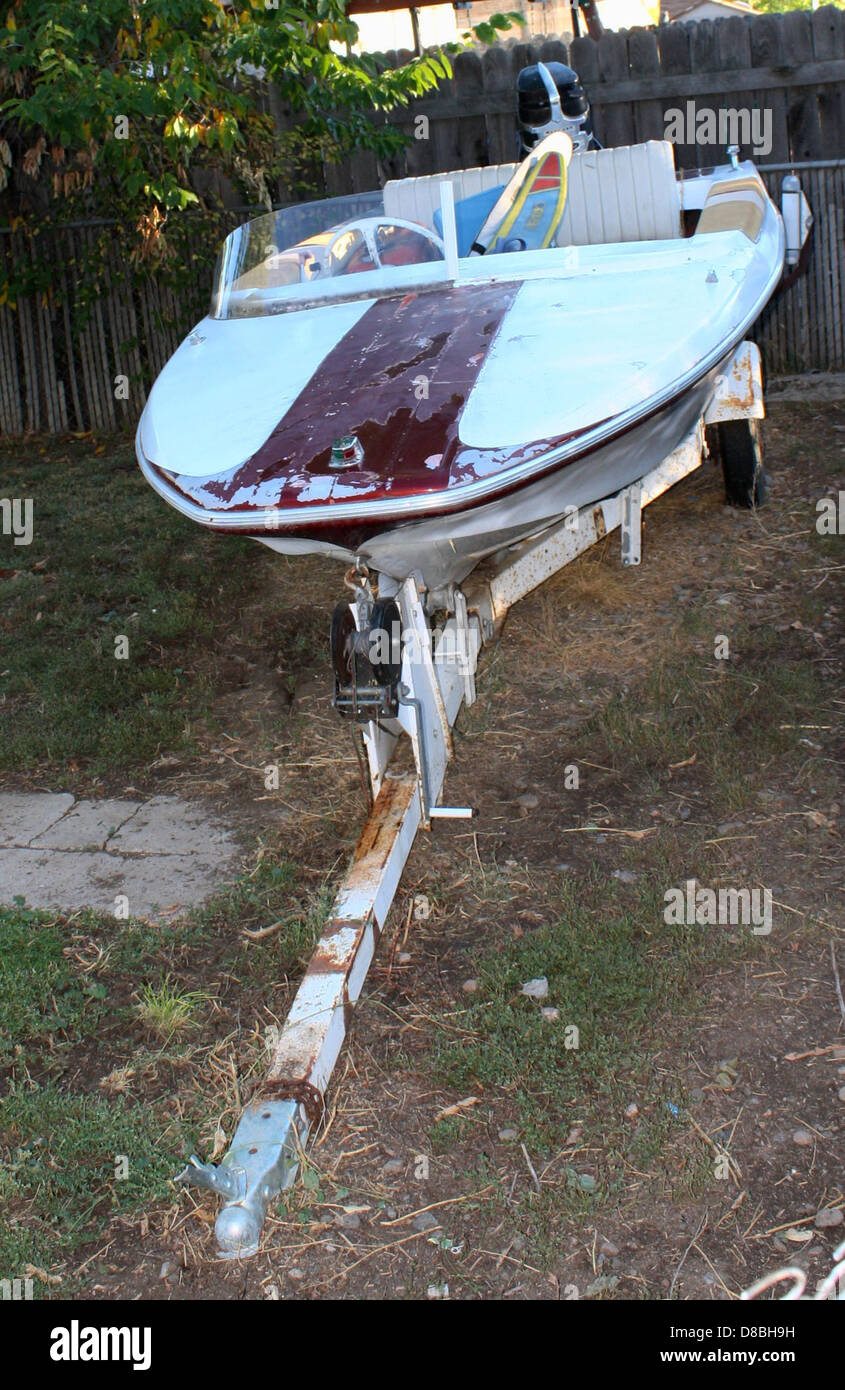 Ein Motorboot wird im Hinterhof gezeigt, wahrscheinlich neben einem Gewässer. Die Anwesenheit des Bootes deutet auf den Zugang zu Freizeitaktivitäten von zu Hause aus hin. Stockfoto