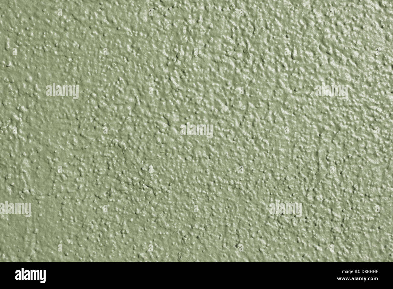 Eine Nahansicht einer olivgrün bemalten Wand, die die glatte Textur der Farbe zeigt. Die Farbe der Wand verleiht dem Raum eine beruhigende und neutrale Ästhetik mit subtilen Variationen der Lackoberfläche. Stockfoto