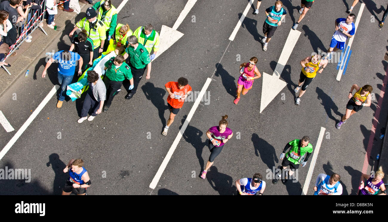 London Marathon 2013 Runner ist Sanitätern entfernt nach einem Zusammenbruch am Victoria Embankment England Europa Stockfoto